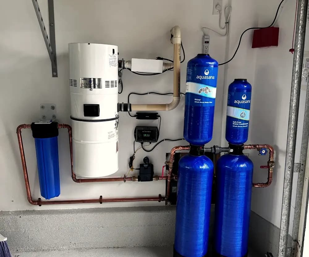 A whole-house filtration and softening system on a garage wall