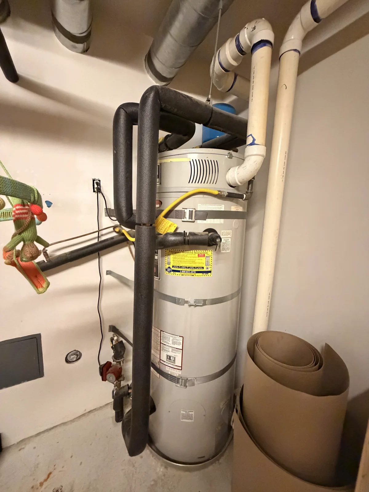 A new gas water heater with an expansion tank above it, a yellow gas connector and new copper lines